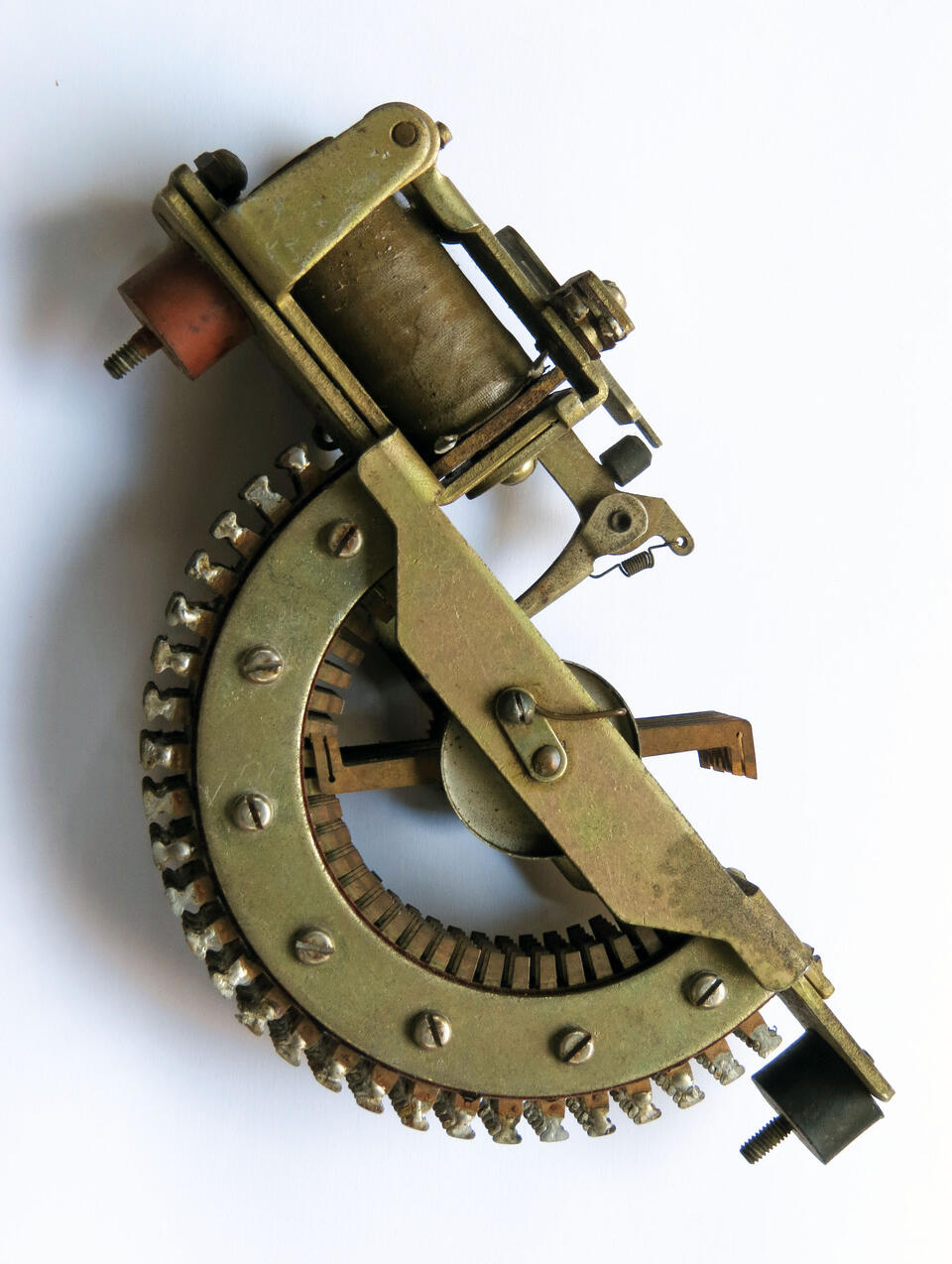 Color photograph: Vintage radial stopper switch, a bronze-colored machine part against a plain white background.